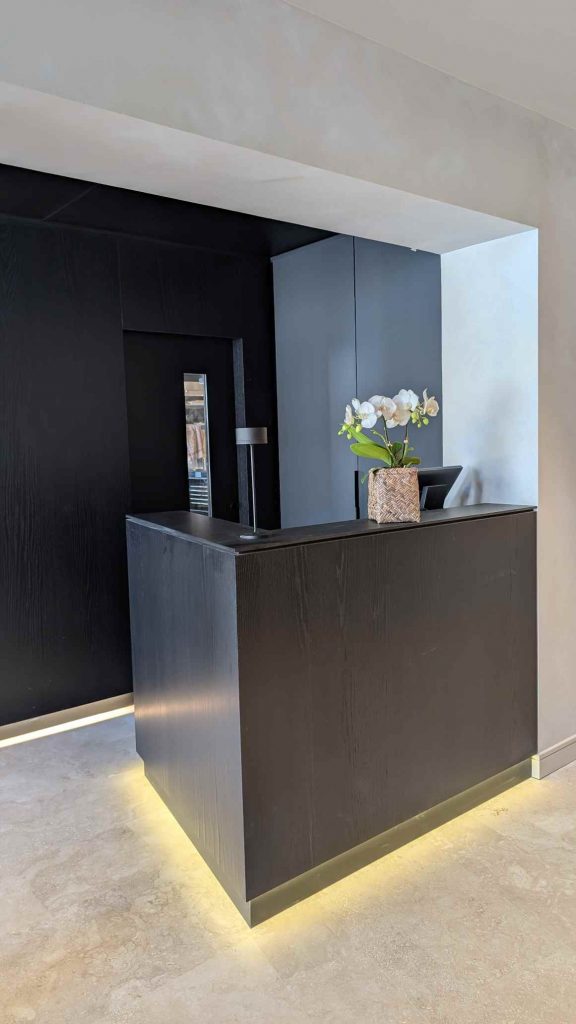 Mobilier sur mesure en bois stratifié rétroéclairé LED pour aménagement de restaurant – banque d’accueil sur mesure, réalisé par un menuisier agenceur à Metz