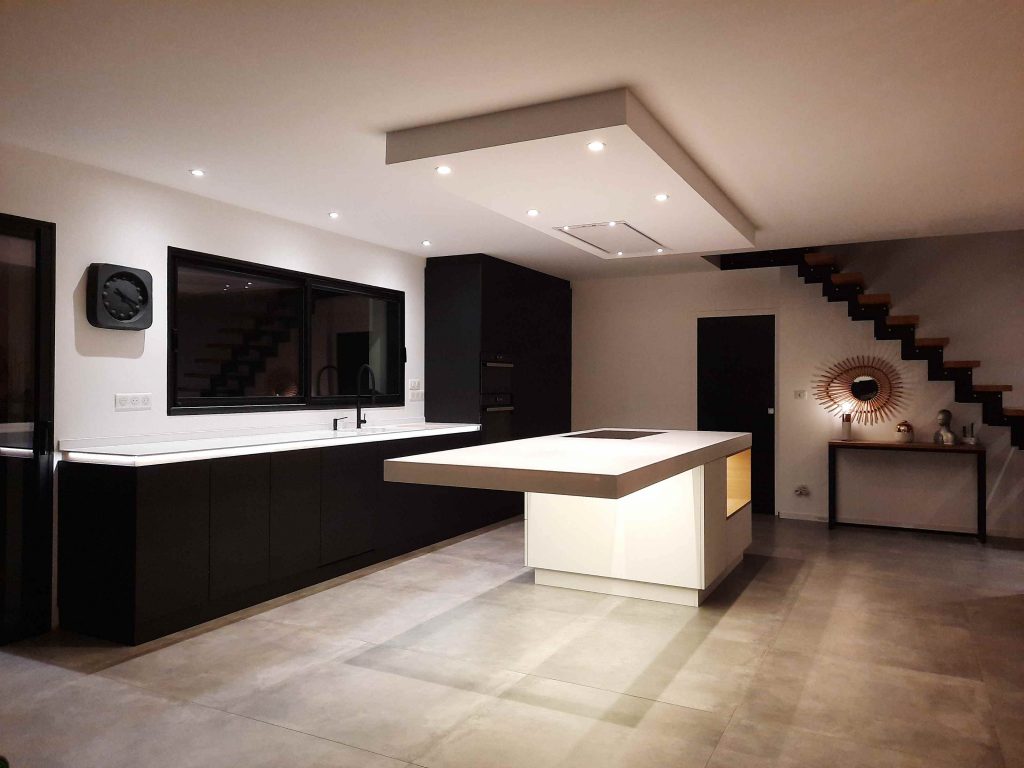 Cuisine sur mesure en Corian et chêne noir avec îlot central et colonnes de rangement à Metz