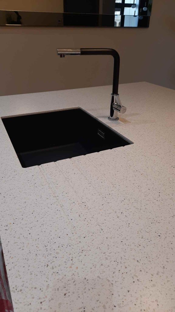 Cuisine contemporaine en noyer et Corian noir avec colonnes sur mesure à Metz