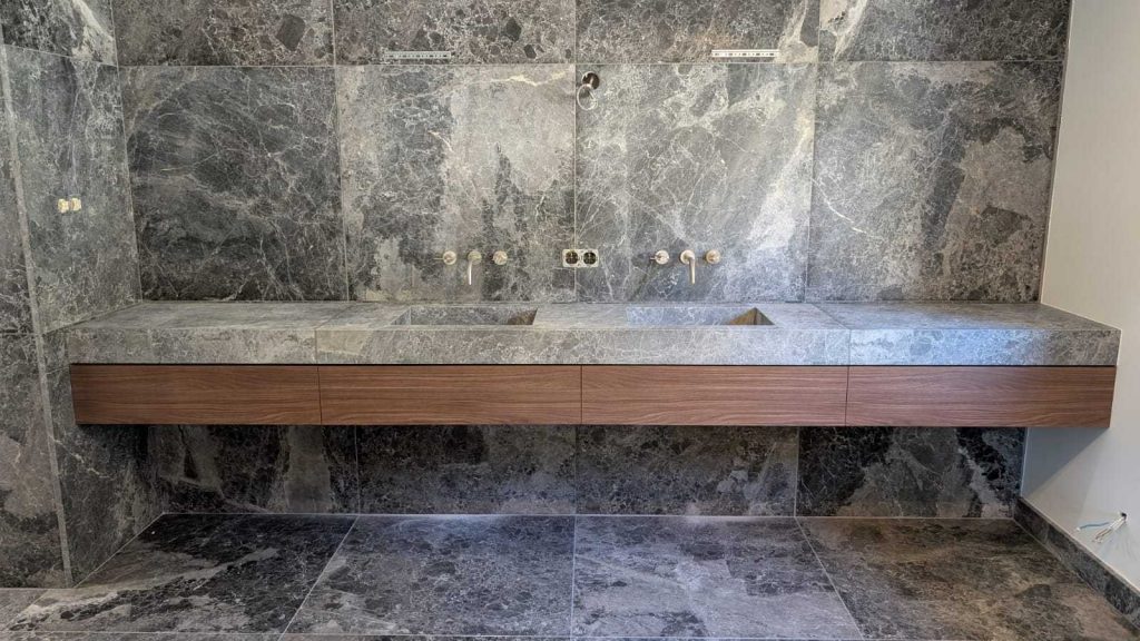 Salle de bain sur mesure au design contemporain en noyer et marbre avec meuble vasque, réalisé(e) à Epinal par un menuisier agenceur.